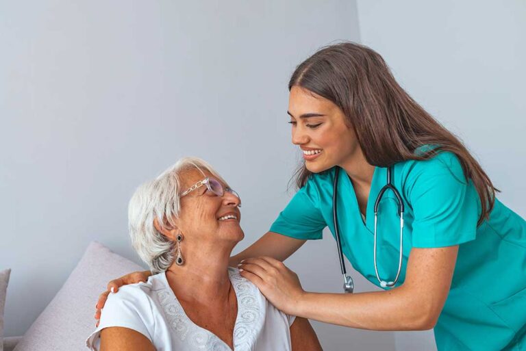 A diverse group of older adults smiling together in a bright, welcoming community room.